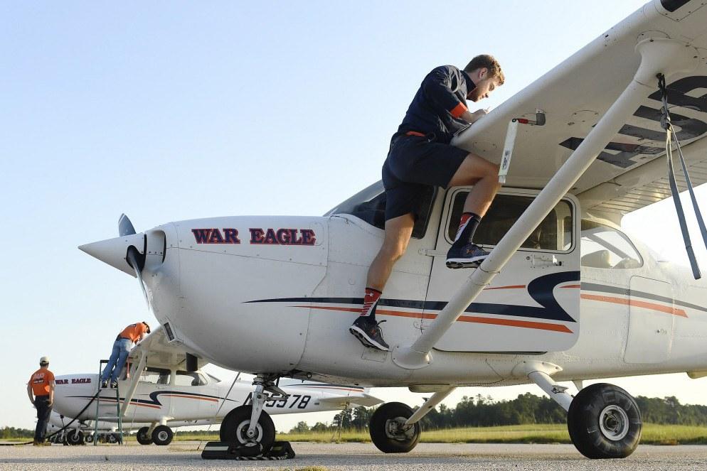 Auburn Student climbing into an airplane